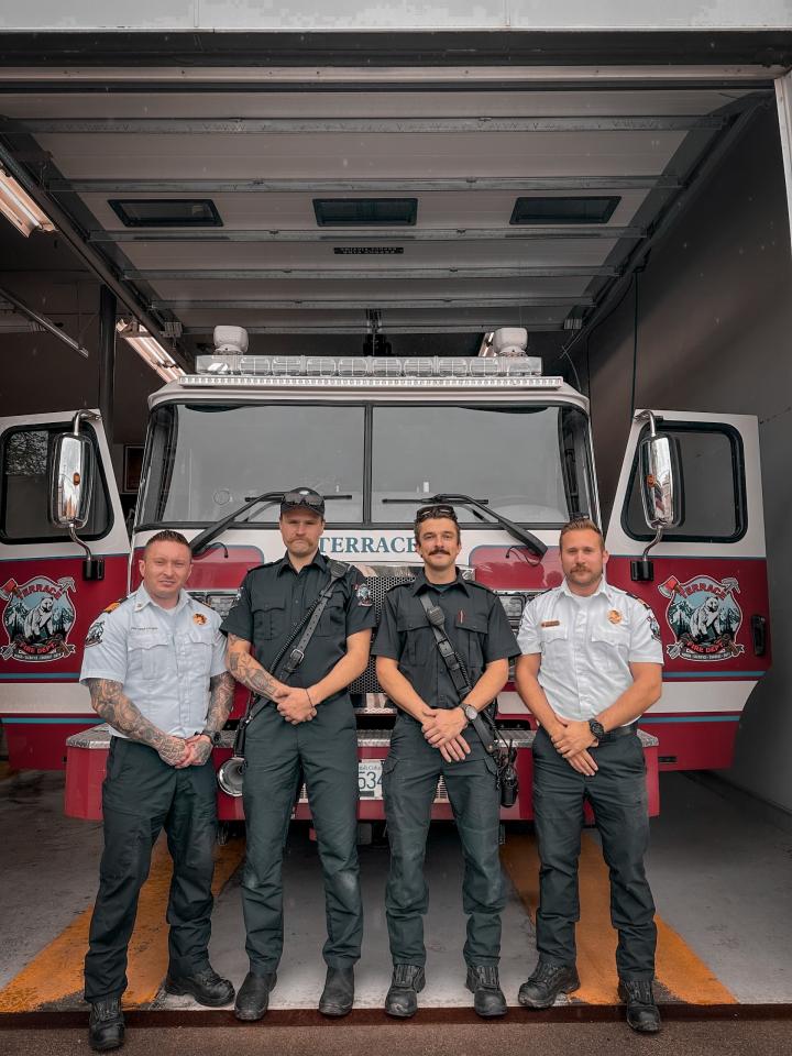 Chad Cooper, Shayle Prins, Mike Krueger, and Joel Brousson stand in front of a City of Terrace fire truck