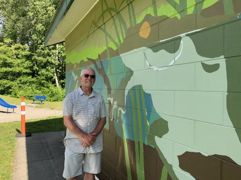 TFC manager Kim Haworth stands with partially completed mural 